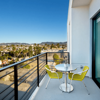a balcony with a table and chairs and a view of the city